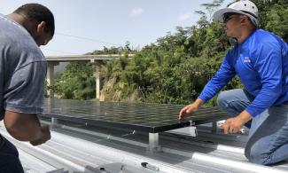  Members of environmental nonprofit Casa Pueblo install solar panels in Puerto Rico’s Adjuntas community. Photo by Arturo Massol.