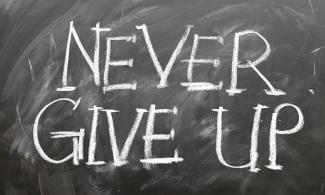 Chalk board reading "never give up"