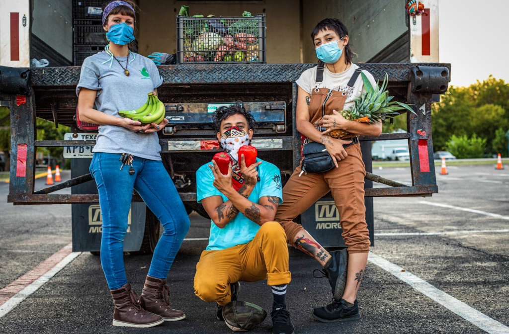 Volunteers for the Harvest Project Food Rescue pose with fresh produce. With the help of community partners, they distribute free fresh produce baskets to hundreds of families a week.