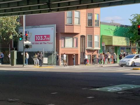 People waiting in line outside of Rainbow Grocery.