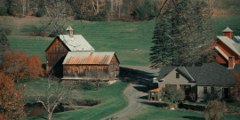 Farm houses and barns in a green meadow. Photo by Vanessa Sezini on Unsplash