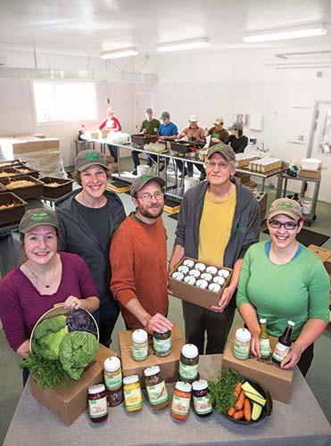 Employees and co-owners of worker-owned co-op Real Pickles show off available products and pack jars for sale. Photo by Valley Lightworks.