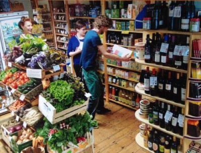 Caroline Kempster (left, behind vegetables) and two fellow members of Trinity Wholefoods in the shop. Photo: Trinity Wholefoods